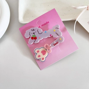 Détail de pinces à cheveux chiot violet et ours mignon sur une carte rose de présentation