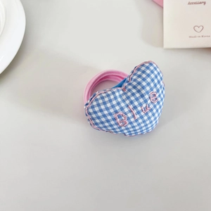 Close-up of heart-shaped blue plaid hair scrunchie with GIVE embroidery and pink elastic