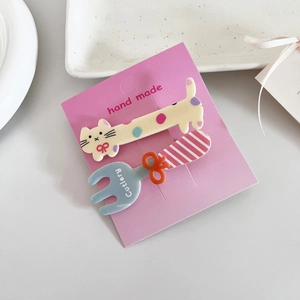 Détail de barrettes mignonnes en forme de chat et couverts avec nœuds sur carte