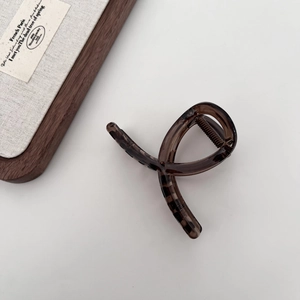Detail of elegant dark brown tortoiseshell hair claw clip with smooth glossy finish