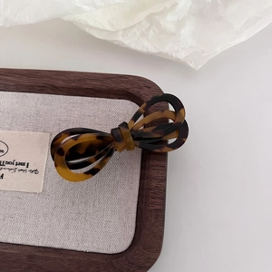 Close-up of acetic acid hair clip with retro tortoise shell pattern on a wooden tray