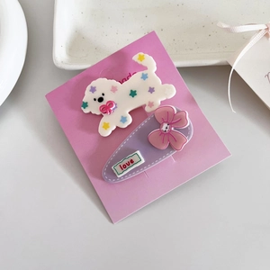 Détail de barrettes mignonnes chiot et chat avec un nœud rose sur carte de présentation