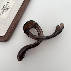 Macro detail of a 13cm dark brown translucent hair claw clip on a jewelry box display