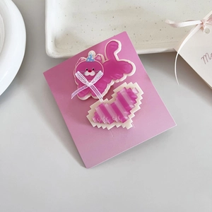 Détail de mignonnes barrettes chat rose et coeur avec texte sur support papier