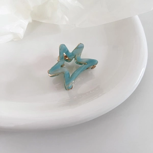Acetate star-shaped hair claw with blue marble pattern and golden metal frame