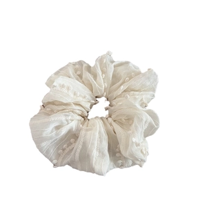 Elegant beige scrunchie with tassel detail and embroidery for women's hairstyle