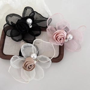Close-up of mesh rose hair ties with pearls and rhinestones on a wooden tray