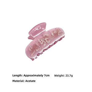 Detailansicht der rosa Acetat-Haarklammer mit Strasssteinen und Muscheltextur