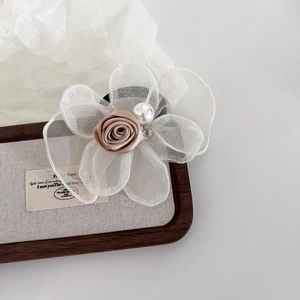 Elegant misty rose hair tie with mesh petals, pearl and rhinestone accents on tray