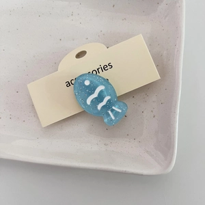 Detalle de pinza para el pelo con forma de pez azul translúcido y purpurina plateada