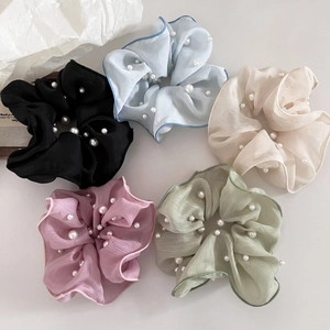 Detailansicht von fünf Perlen-Haargummis aus weichem Pastell-Chiffon und Faltenstoff