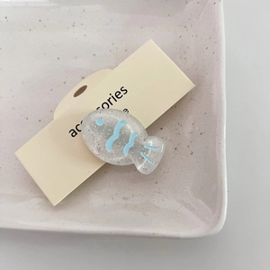 Detalle de pinza para el pelo con forma de pez con purpurina y patrones azules