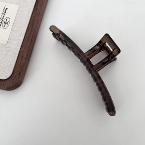 Macro shot of 13cm dark tea claw clip featuring vintage tortoiseshell texture and metal spring