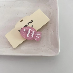 Pinza para el pelo de pez rosa brillante en una elegante tarjeta de presentación crema