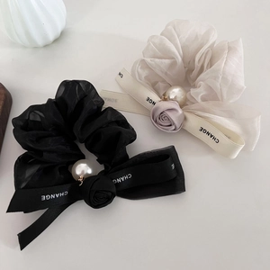 Detail of organza scrunchies with satin rose, pearl charm and CHANGE ribbon