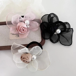 Detail of satin and mesh rose hair ties featuring artificial pearls and rhinestones