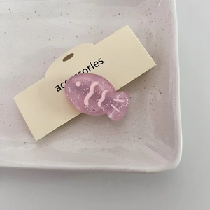 Pinza para el pelo de pez rosa brillante con purpurina en plato de cerámica