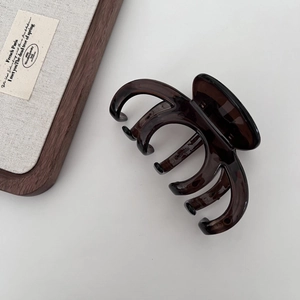 Macro view of a 13cm dark amber hair claw clip with smooth polished finish on white backdrop