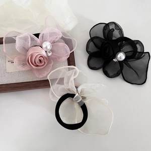 Three mesh rose hair ties with pearls and rhinestones in pink, black, and beige