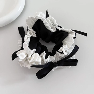 Elegant black and white scrunchie with lace trim and black satin bows for hair styling