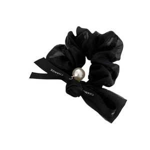 Elegant black mesh scrunchie with a satin bow, pearl accent and Change lettering
