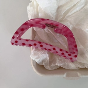Detailed view of pink strawberry polka dot hair claw clip with sturdy metal spring mechanism