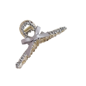 Pince à cheveux élégante en satin gris avec bordure perlée argentée sur fond blanc