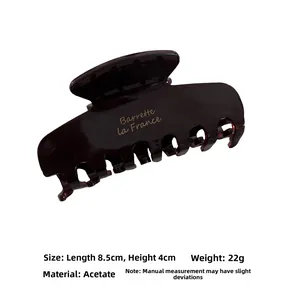 Detail of dark tortoiseshell acetate hair claw clip with French lettering and dimensions