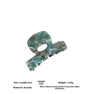 Détail d'une pince à cheveux en acétate marbré mesurant 6x4 cm avec spécifications