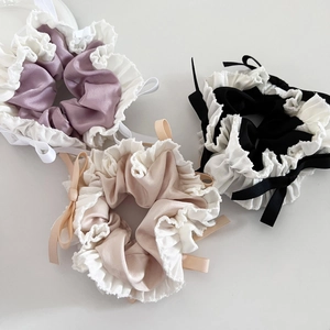 Detailed set of three satin hair scrunchies with lace edges and ribbons in purple, beige and black