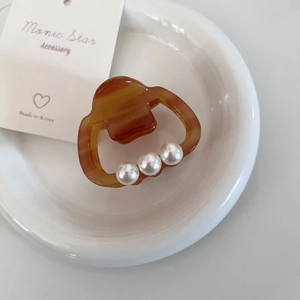 Pince à cheveux carrée en acétate écaille ambrée avec perles sur plateau en céramique