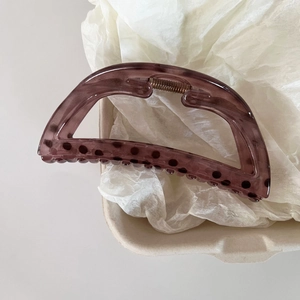 Detail of translucent purple shark hair clip with black polka dots and metal spring