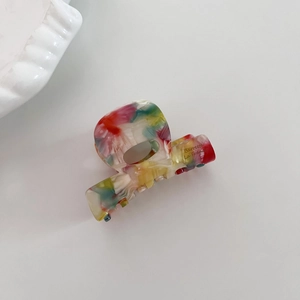 Vue détaillée d'une mini pince à cheveux en acétate avec marbrure colorée et texte français