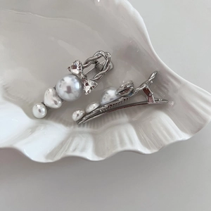 Sparkling rhinestone bow and pearl hair clip set in a white decorative shell tray