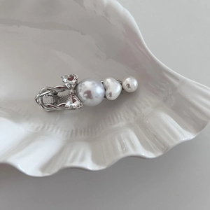 Elegant silver bow hair clip with sparkling rhinestones and white pearls on shell plate