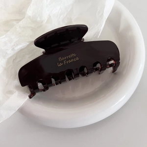 Detailed macro view of dark coffee acetate hair claw with golden Barrette la France text