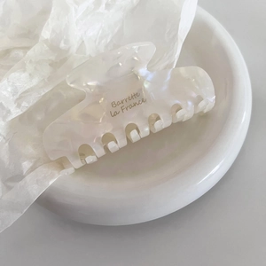 Detailed macro view of pearlescent cream acetate hair claw with Barrette la France text
