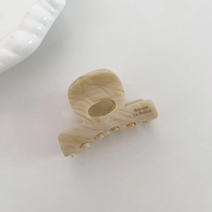Détail de la pince à cheveux en acétate marbré crème avec l'inscription Barrette La France