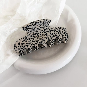 Detailed macro view of the spotted acetate hair claw with golden Barrette la France logo