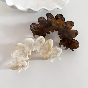 Elegant wavy acetic acid hair claws in amber brown and cream marble texture