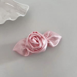 Detaillierte Makroansicht einer eleganten rosa Satin-3D-Rosen-Haarklammer mit Glanzeffekt