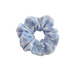 Blue gingham fabric scrunchie with light blue floral embroidery and letter patterns