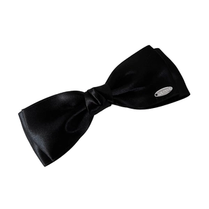 Elegant black satin double-layered bow hair clip with silver brand tag on white background