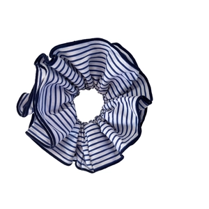 Chouchou en tissu à rayures bleues et blanches avec bordure marine sur fond blanc