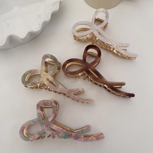 Detail of elegant acetate ribbon bow hair claws in marble and tortoiseshell patterns