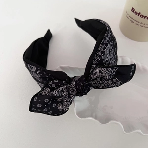Retro black paisley print wide headband with bow knot decoration on white tray