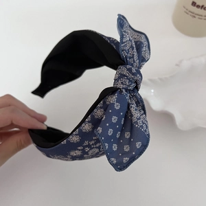 Close-up of vintage blue paisley bow headband with detailed ethnic fabric and soft padding