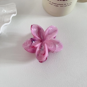 Vue détaillée d'une pince à cheveux fleurie rose et violette avec motif marbré