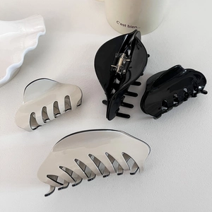 Black and cream acetate hair claws in large and medium sizes on a white surface