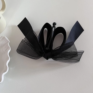 Barrette banane élégante à nœud en maille noire pour femme avec ruban satin sur fond blanc